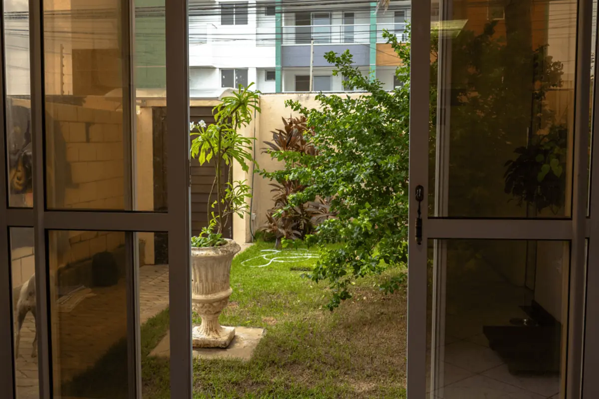 Entrada da KONTAKT, com portas de vidro abertas para o jardim